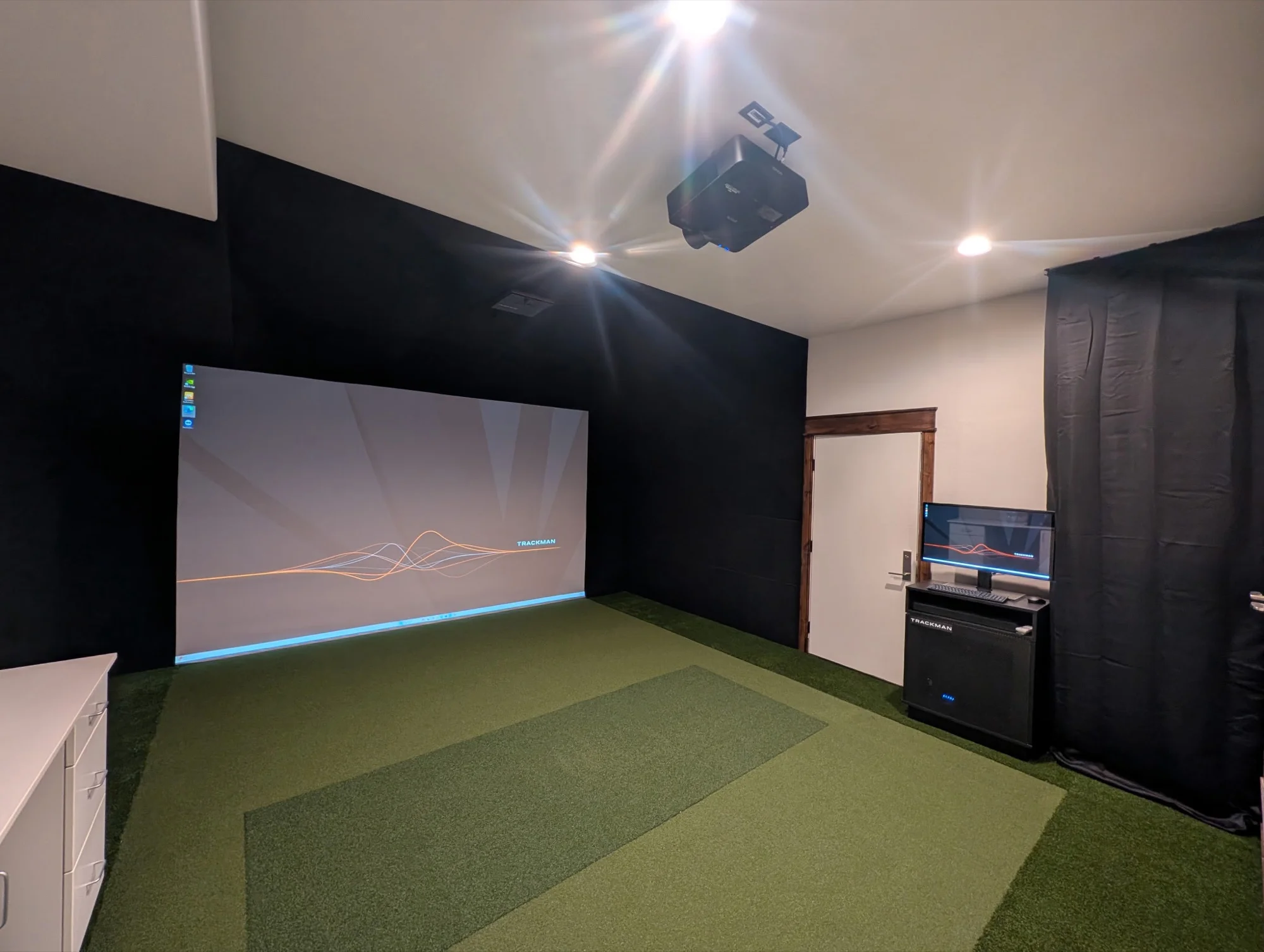 Finished basement room built as a home golf simulator